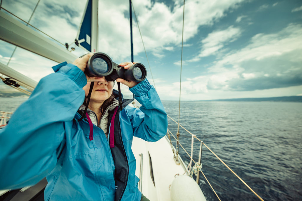 Woman on a boat looking through binoculars